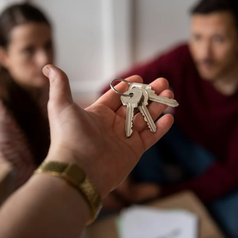 Plusieurs personnes récupérant les clés de leur logement suite à une acquisition en indivision chez le notaire