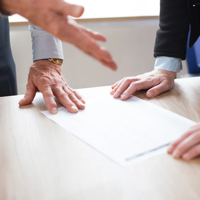 2 personnes concluant un accord pour la transmission d'une entreprise via le Pacte Dutreil.